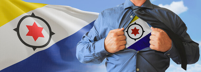 A businessman opening his shirt like super hero with Bonaire flag and shows how patriotic he is by...