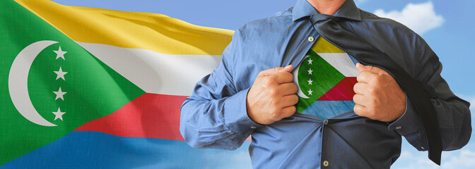 A businessman opening his shirt like super hero with Comoros flag and shows how patriotic he is by...