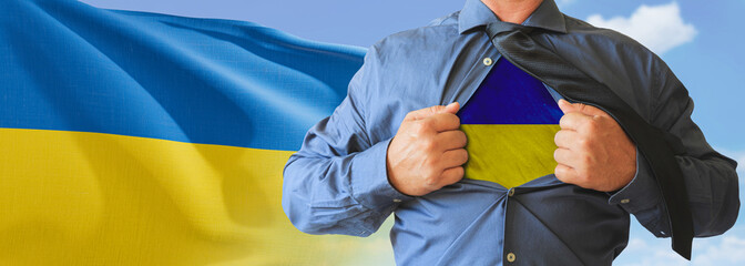 A businessman opening his shirt like super hero with Ukraine flag and shows how patriotic he is by...