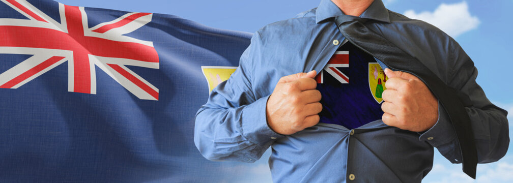 A businessman opening his shirt like super hero with Turks and Caicos Islands flag and shows how patriotic he is by revealing his countries flag beneath printed on a t-shirt.