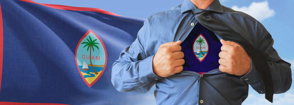 A businessman opening his shirt like super hero with Guam flag and shows how patriotic he is by revealing his countries flag beneath printed on a t-shirt.