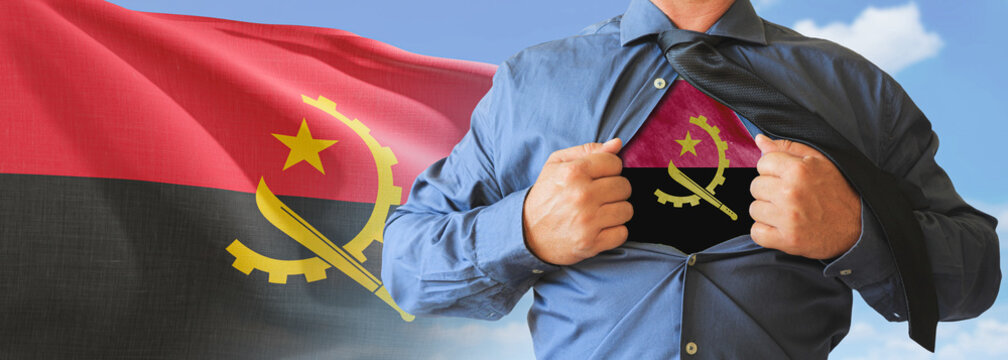 A businessman opening his shirt like super hero with Angola flag and shows how patriotic he is by revealing his countries flag beneath printed on a t-shirt.