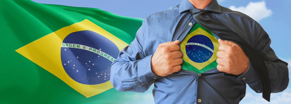 A businessman opening his shirt like super hero with Brazil flag and shows how patriotic he is by revealing his countries flag beneath printed on a t-shirt.