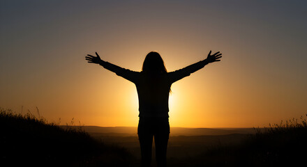 Fototapeta premium Person silhouette with arms wide open embracing the golden light of sunrise or sunset, symbolizing freedom, hope, and peace.
