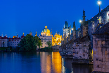 Obraz premium Sunset view of Charles bridge and Saint Salvator church in Pragu