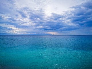 Scenic seascape with turquoise ocean water and dramatic cloudy sky, horizon over calm sea, natural...