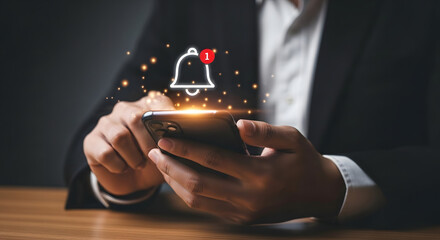 Person using mobile device with notification bell icon and glowing light