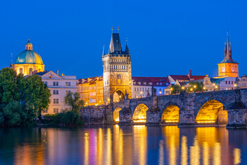 Fototapeta premium Sunset view of Charles bridge and Saint Salvator church in Pragu