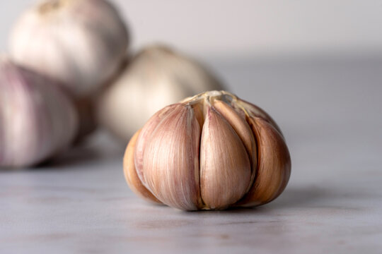 Bulb of purple garlic with the skin removed on a light surface 