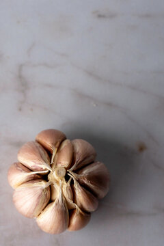 Bulb of purple garlic with the skin removed on a light surface 