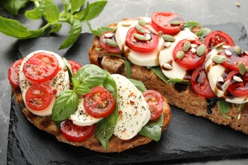Delicious sandwiches with mozzarella cheese and tomatoes on table, closeup