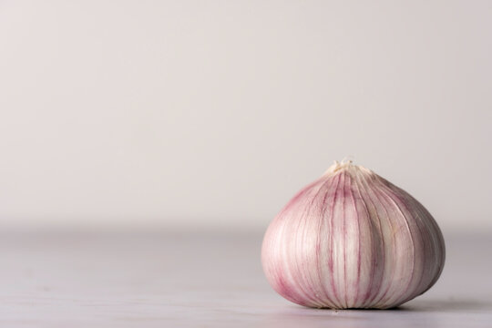 Bulb of purple garlic on a light surface 