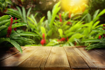 Wooden table in jungle. Empty surface against green tropical plants. Poster with space for design