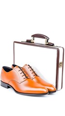 Stylish orange dress shoes paired with a classic briefcase for the modern professional.