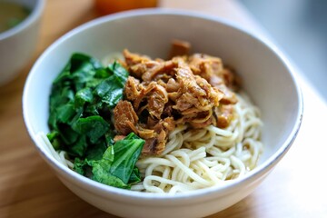 Mie ayam. Noodle with chopped chicken and boiled vegetable. served with chicken broth.