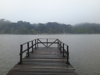 Fototapeta premium Wooden jetty on a lake in the foggy morning.