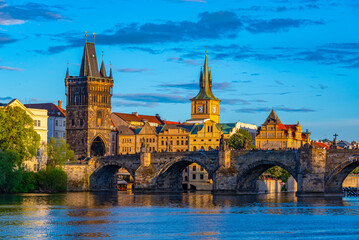 Fototapeta premium Sunset view of Charles bridge and Saint Salvator church in Pragu