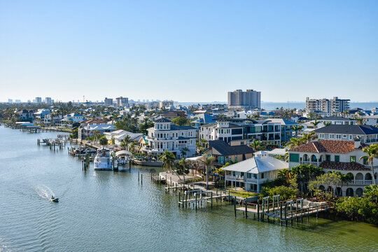 Boat idling by waterfront homes in Fort Myers Beach on Estero Island, southwest Florida in Lee County