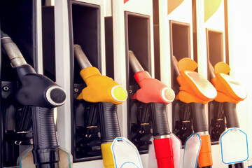 Gas station refueling guns ready for customers to fill up with gasoline or diesel fuel during...