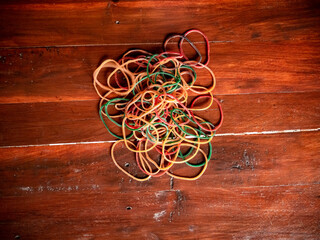 Pile rubber bands on a wooden surface with multiple colors