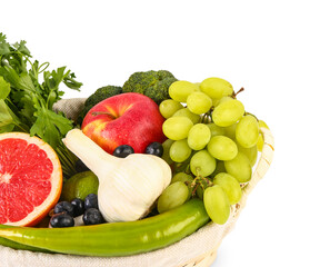 Wicker basket with different fresh fruits and vegetables on white background, closeup