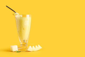 Glass of tasty melon smoothie on orange background
