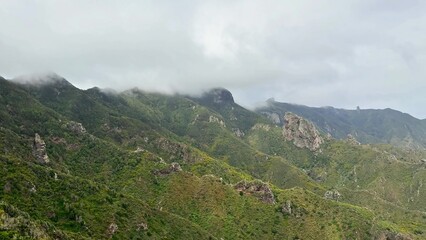Behold the stunning mountain range that lies beneath the vast and cloudy skies above