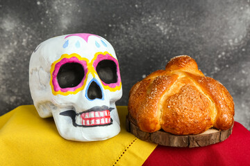 Painted skull for Mexico's Day of the Dead (El Dia de Muertos) and traditional bread on altar