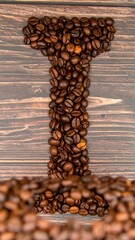 Coffee beans arranged to form the letter I on a wooden background