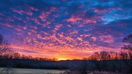 Obraz premium Breathtaking sunset sky with vibrant hues of pink, orange, and purple, painting clouds in an ethereal display that highlights nature's beauty and captures the serene magic of dusk.