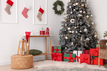 Interior of living room with Christmas tree, presents and table