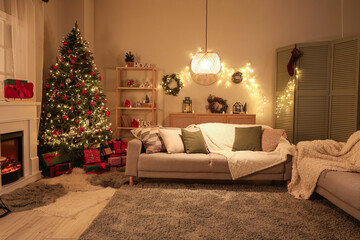 Interior of festive living room with fireplace, Christmas tree and glowing lights at evening