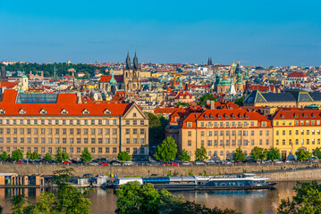 Obraz premium Towers above the old town of Prague behind leaves, Czech republi