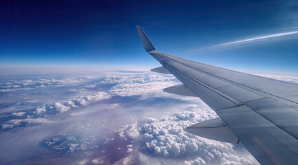 Obraz premium Airplane wing over vast clouds