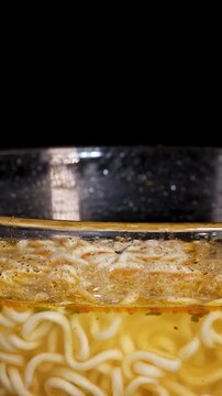 Rotating Close-Up of Instant Noodle Bowl in Broth