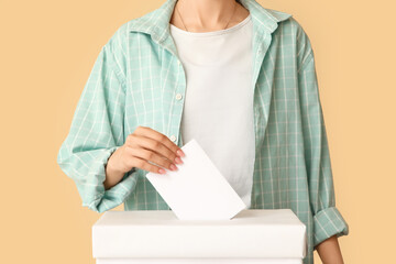 Voting woman near ballot box on beige background, closeup