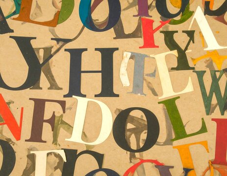 Assorted colorful paper letters on kraft paper