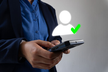 Authorized user: Close-up of a business person's hands holding a smartphone and a user profile icon with a check mark.