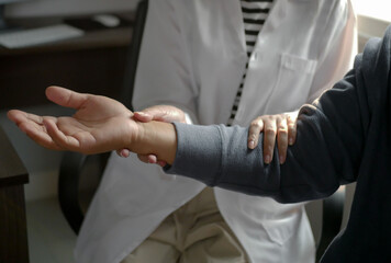 A male patient receives physical therapy from a specialist physical therapist in an examination...