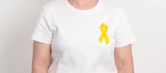 Elderly with Yellow Ribbon for concept of yellow September, Suicide prevention day, Childhood, July Sarcoma, October Spina bifida awareness month , support survivor. Healthcare and World Cancer day