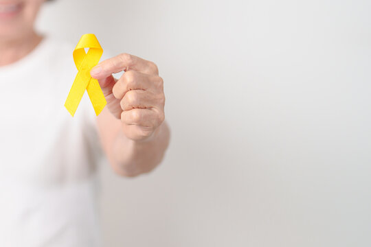 Elderly with Yellow Ribbon for concept of yellow September, Suicide prevention day, Childhood, July Sarcoma, October Spina bifida awareness month , support survivor. Healthcare and World Cancer day