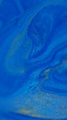 Blur glitter. Liquid shimmer. Defocused blue yellow color marble texture shiny water fluid enamel floating on abstract background.
