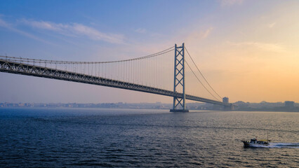 日本の明石大橋の朝焼けと小さな船