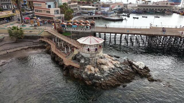Toma aerea de una plaza en un muelle entre rocas en la orilla del mar