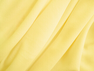 Yellow fabric background. Wavy cloth texture