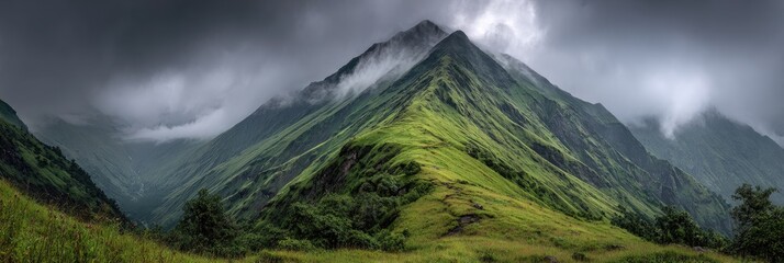 Lush mountain peaks shrouded in mist.  Dramatic, verdant slopes ascend into a cloudy sky