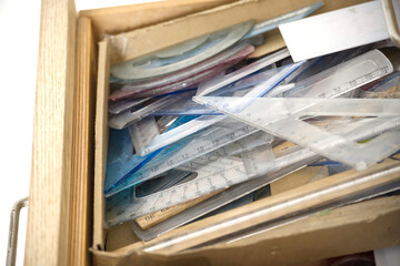 A drawer filled with various rulers and geometric tools for measurement.