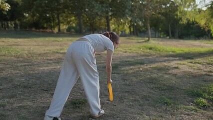 Redheaded woman in white attire playing frisbee with dark clothed friend, enjoying recreational moment amid lush park greenery under bright sunlight - Powered by Adobe