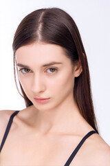 Close-up Image of a woman on a white background. She has brown hair and brown eyes. She's wearing a black bra. She's looking straight at the camera.