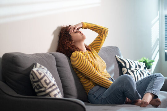 Young hispanic woman feeling sad and depressed at home on sofa